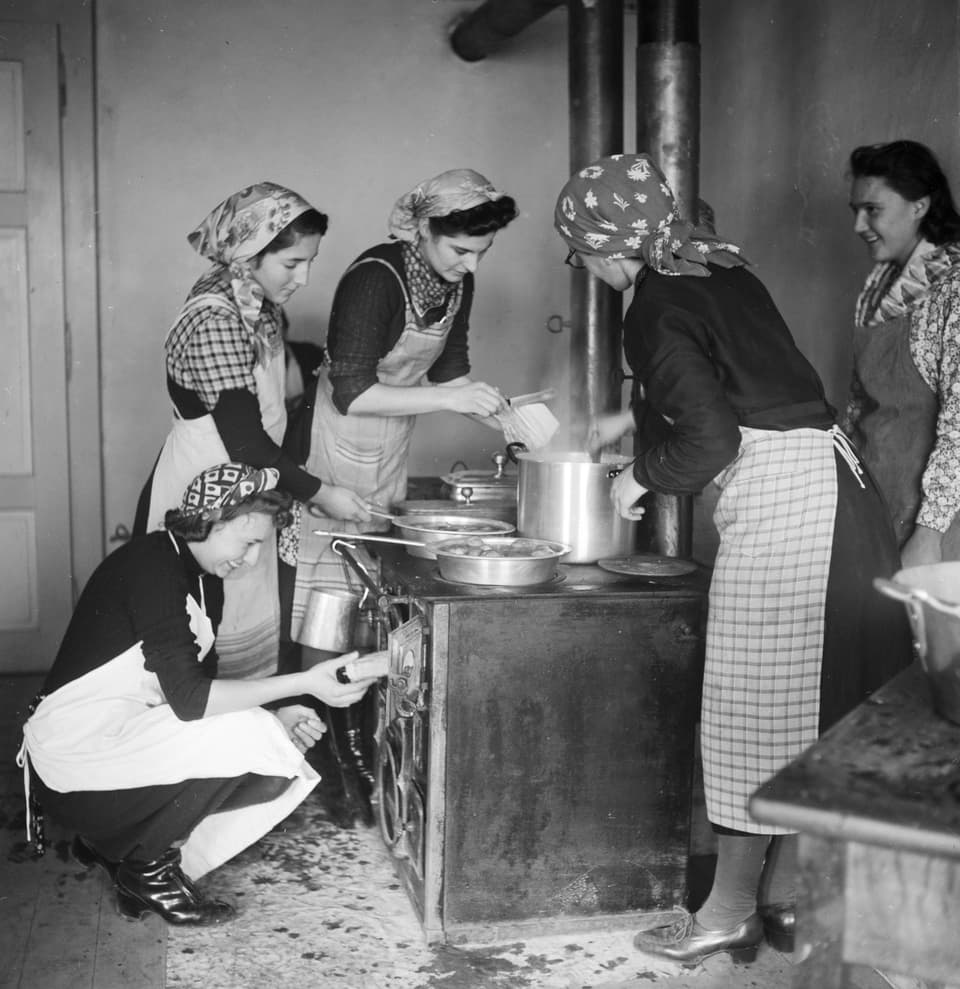Frauen touren mit sogenannten "Fahrende Küchen" durch die Dörfer um in jenen, welche keine eigene Haushaltungsschule haben, Haushaltungsunterricht zu erteilen. Junge Frauen beim Unterricht im Dorf Ardon im Wallis.