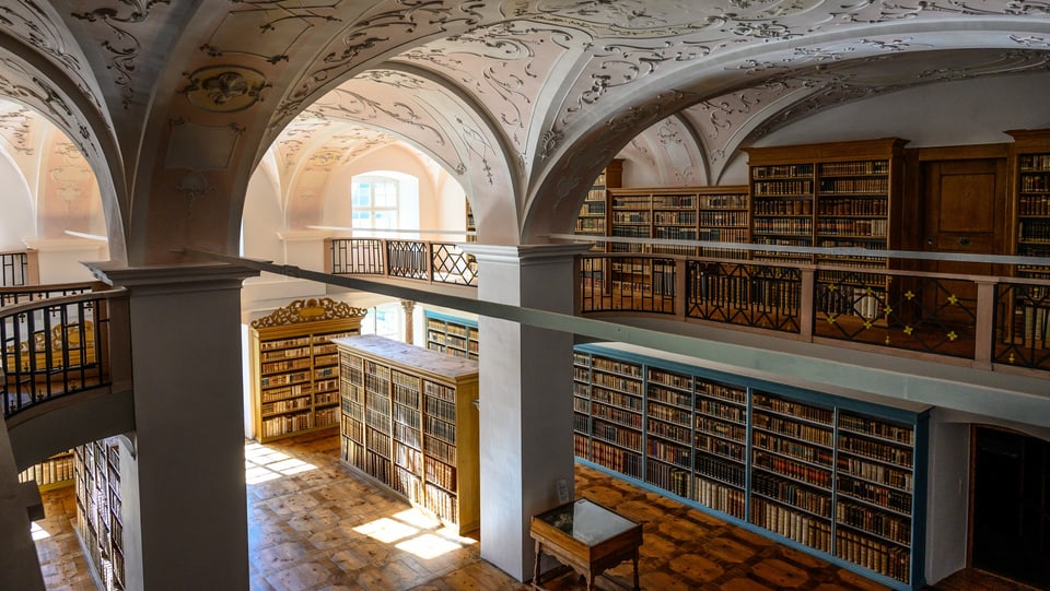 In einem schönen Raum stehen unzählige Regale voller Bücher.