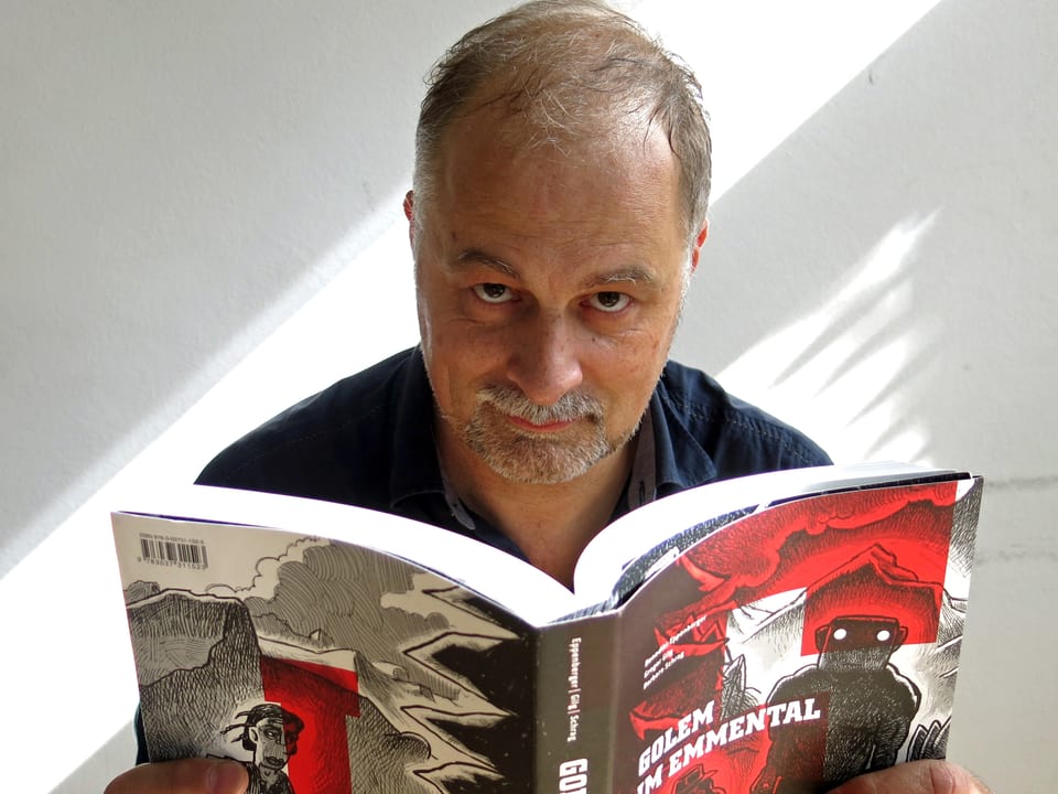 Autor Benedikt Eppenberger hält sein Buch «Golem im Emmental» in den Händen.