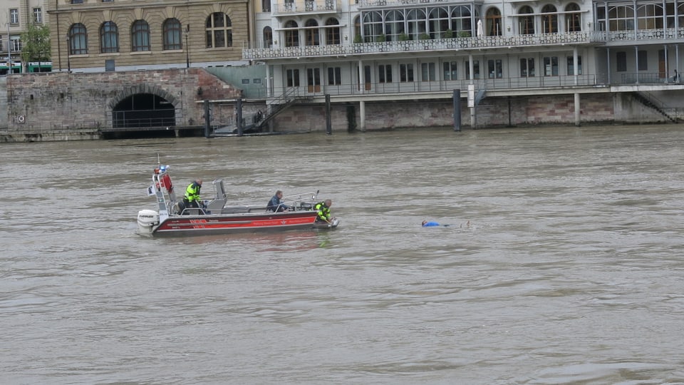 Person im Wasser ist etwa 2 Meter vom Rettungsboot entfernt.