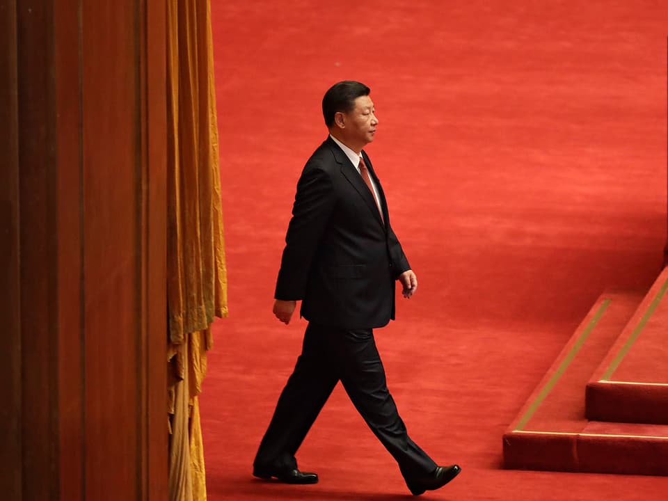 Xi schreitet auf rotem Teppich.