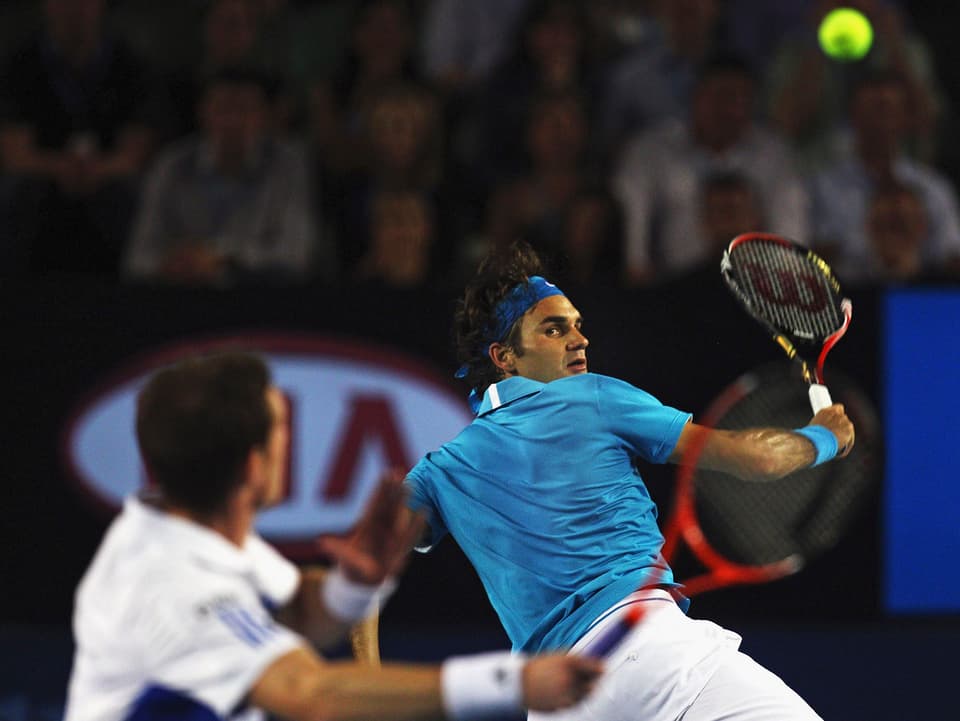 Federer spielt eine Backhand mit dem Rücken zum Netz.