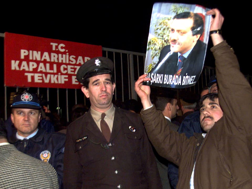 Ein Erdogan-Unterstützer mit einem Plakat vor Sicherheitskräften.