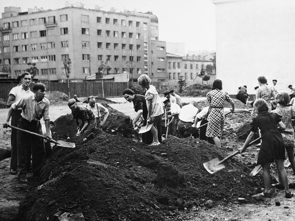Polnische Männer und Frauen schaufeln in Warschau einen Schützengraben.
