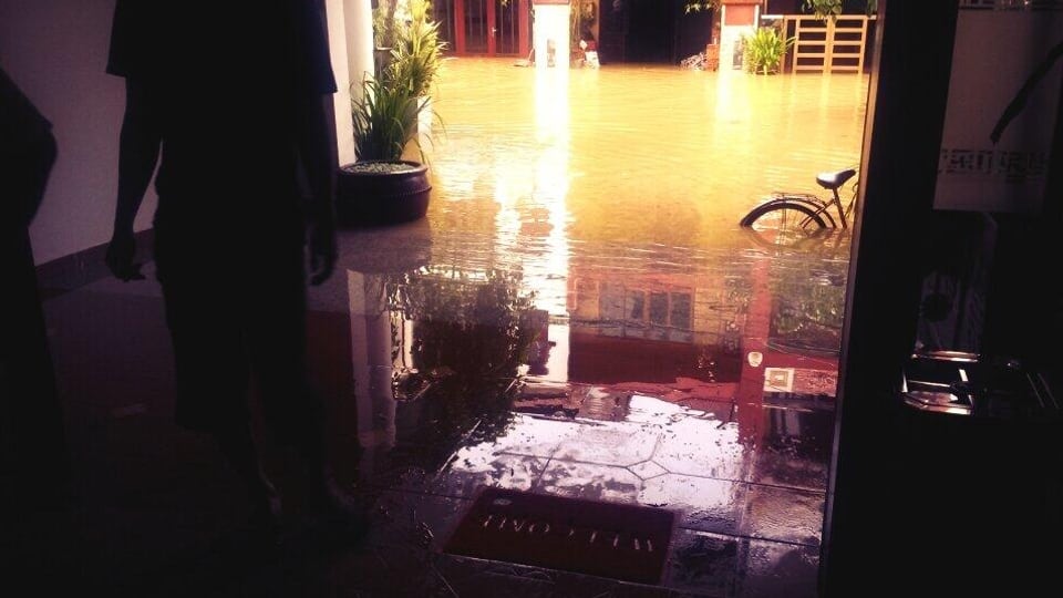 Ein überschwemmter Hoteleingang mit einem Fahrrad, das im Hintergrund überspült im Wasser steht.