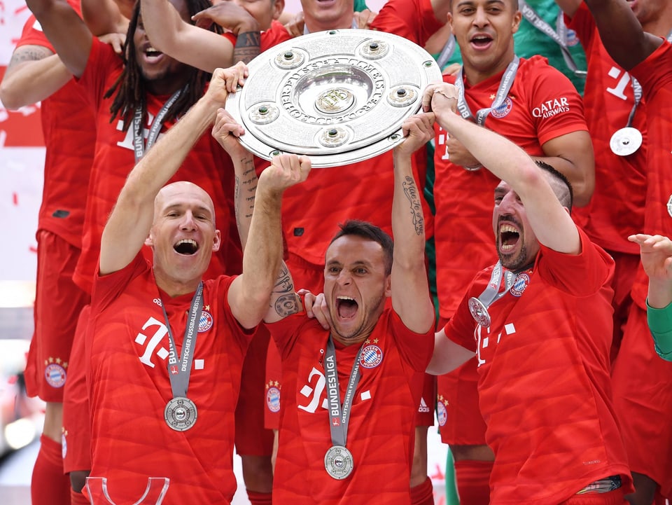 Die scheidenden Arjen Robben, Rafinha und Franck Ribéry stemmen gemeinsam die Meisterschale.