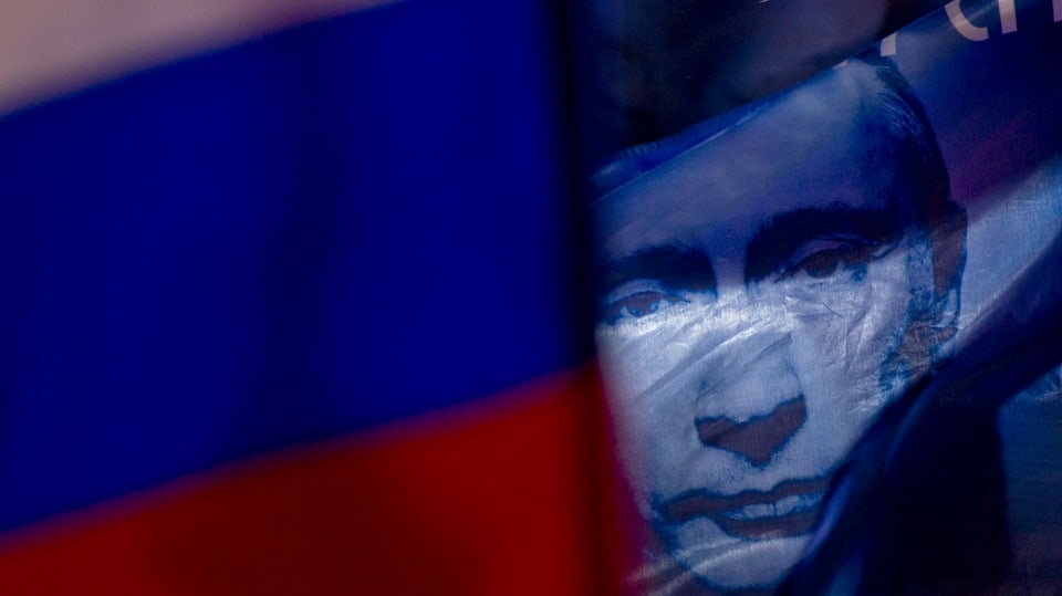 Putin-Bild hinter einer Russland-Flagge