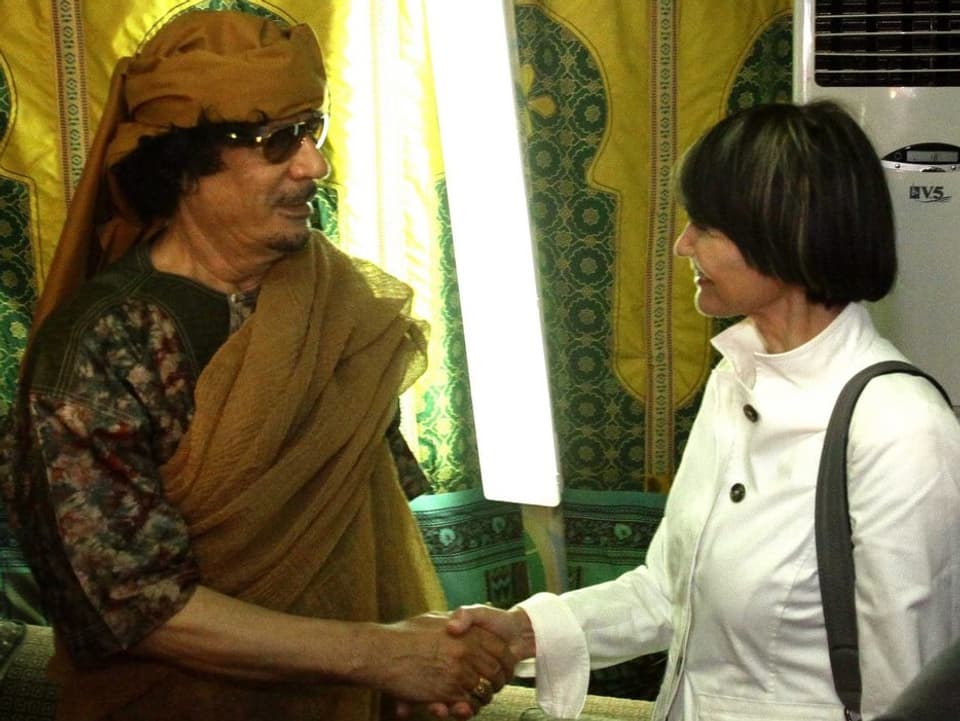 Muammar Gaddafi (links) schüttelt Micheline Calmy-Rey (rechts) die Hand.
