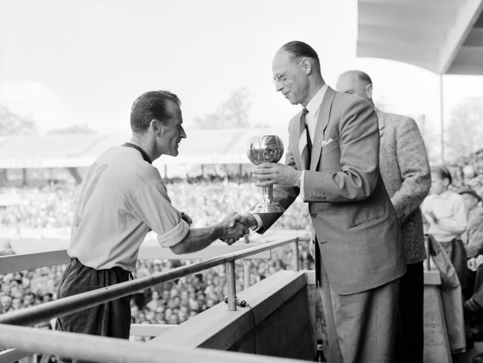 1957 gewinnt YB den 7. Meistertitel der Klubgeschichte. Im alten Wankdorf-Stadion nimmt der damalige Captain Hans Grütter den Pokal entgegen.