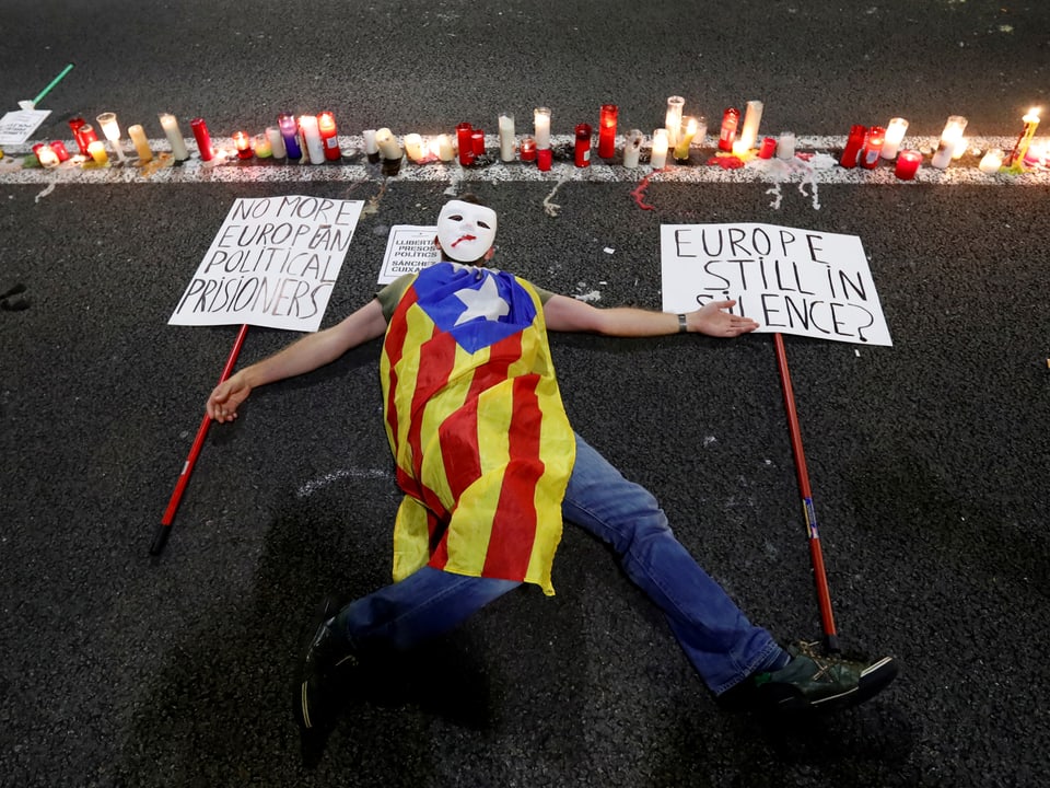 Ein Demonstrant liegt mit einer Katalonien-Flagge am Boden
