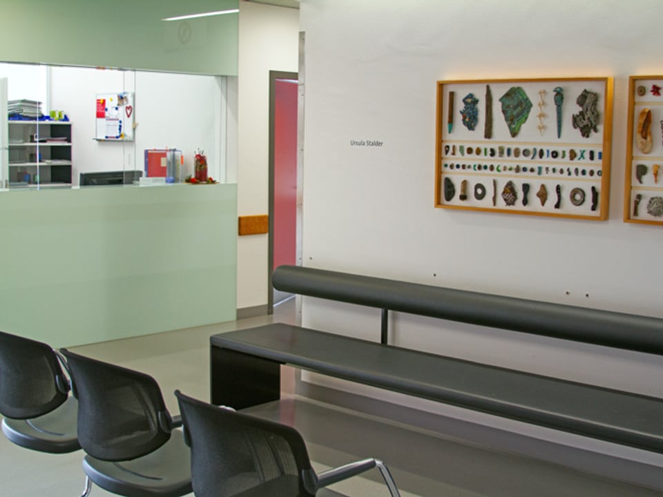 Drei leere Stühle vor zwei Bildern.