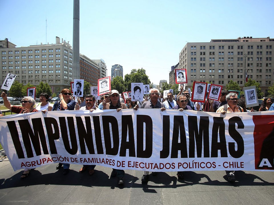 Demonstranten mit Schildern und einem Transparent mit der Aufschrift «Impunidad Jamas».