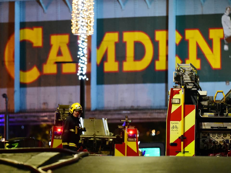 Feuerwehrmänner vor einem grossen Camden-Schild.