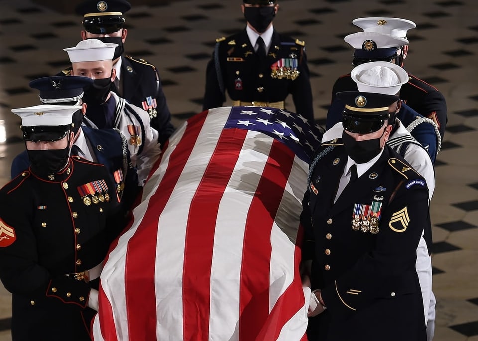 Militärs tragen einen Sarg, mit US-Flagge bedeckt.