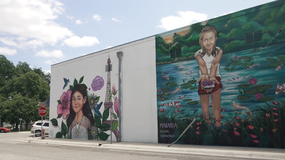 Graffittis auf Fassade, zwei Mädchen, eines neben Eiffelturm