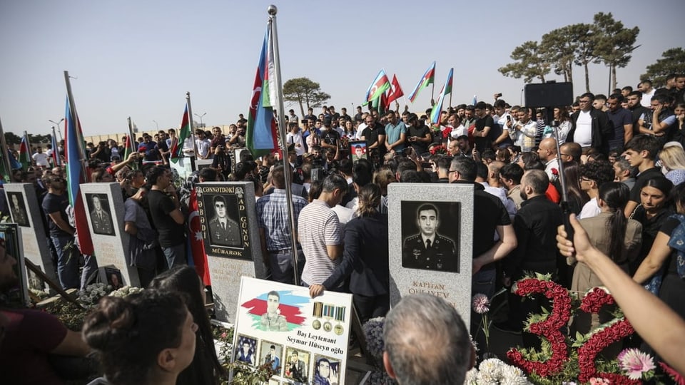 Eine Ansammlung trauerender Menschen mit Fotos der getöteten Soldaten