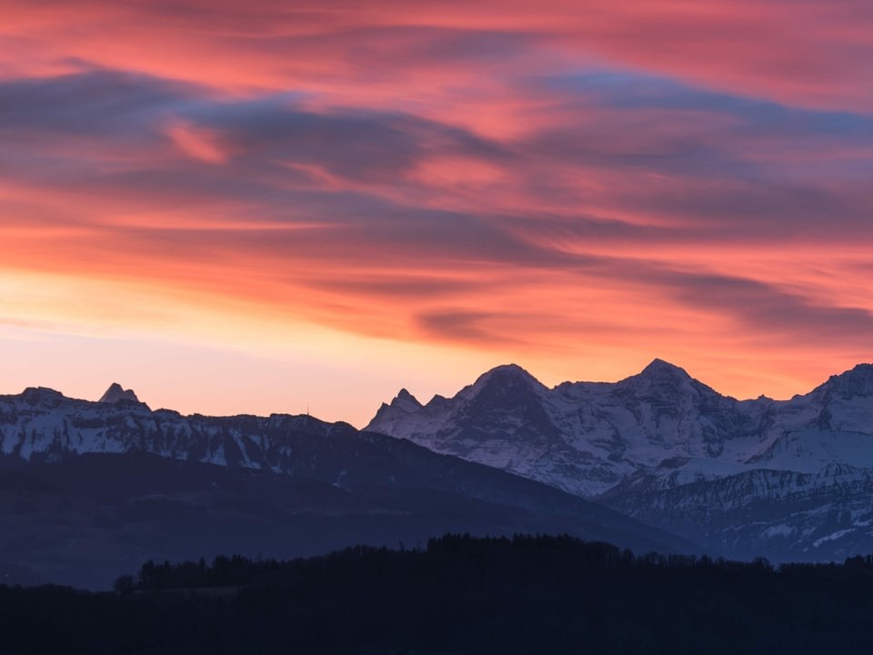 Blick auf Schneeberge mit roten Wolken am Himmel