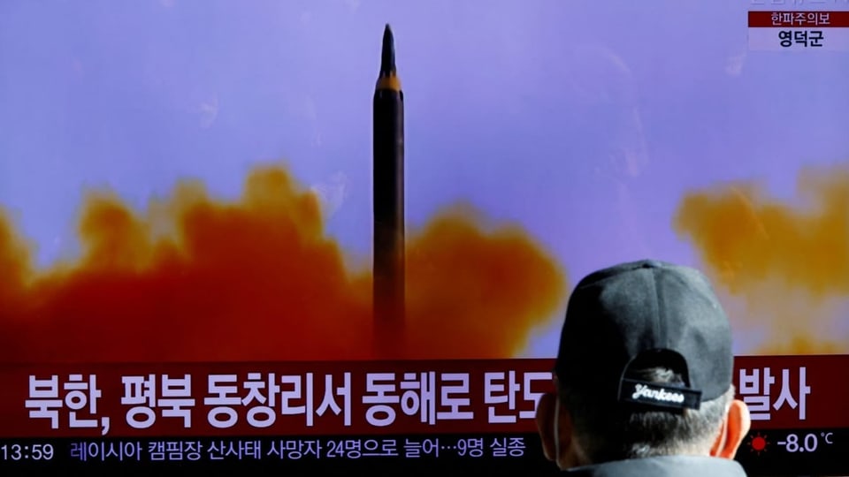 Ein Nordkoreaner beobachtet den Raketentest im Fernsehen.