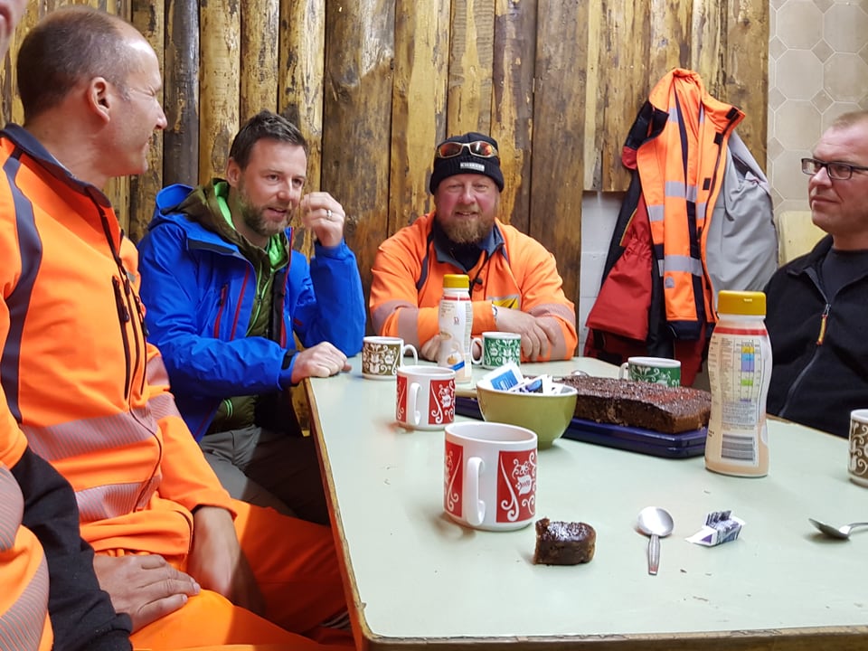 Eine Gruppe Arbeiter mit Nik Hartmann beim Znüni-Kafi. 