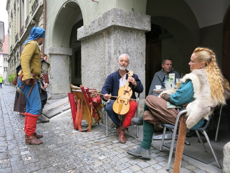 Geigenspieler und Leute in Kostümen am Rathausfest.