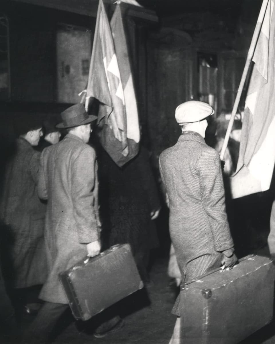 Schwarzweiss-Foto junge Männer, wartend, stehend, mit Gewehr in der Hand.