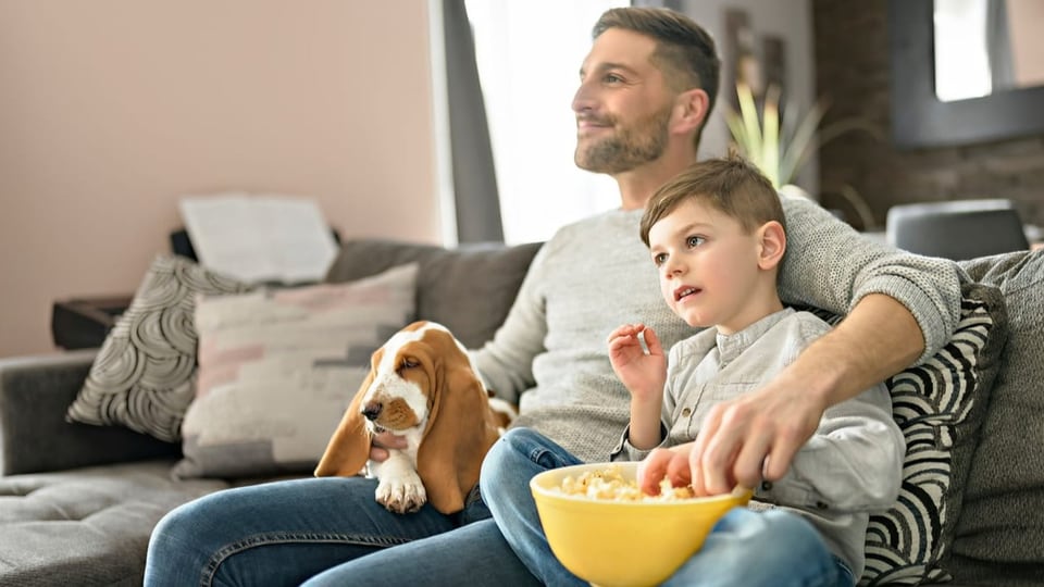 Mann mit Kind auf dem Sofa.