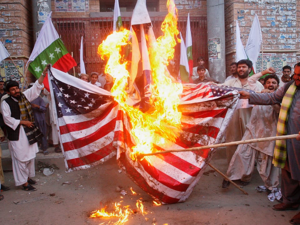 Demonstranten verbrennen eine US-Flagge.