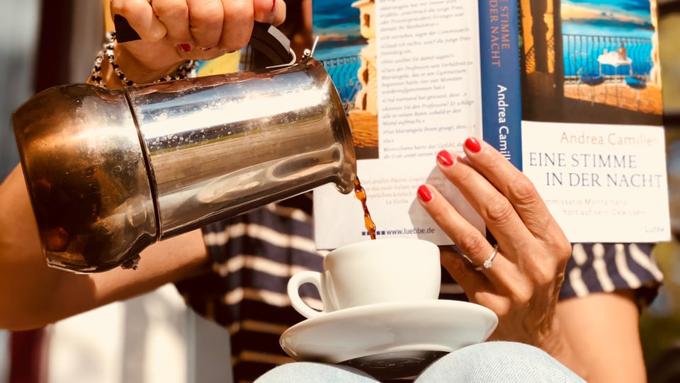 Annette König hät den Krimi «Eine Stimme in der Nacht» von Andrea Camilleri in der Hand und giest gleichzeitig aus der Moka-Kanne ein Espresso in eine kleine Tasse, die sie auf ihren Knien jongliert.