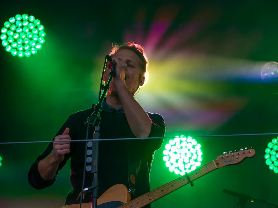Hecht-Sänger Stefan Buck singt im grünen Scheinwerferlicht.
