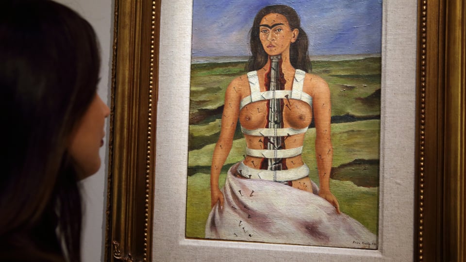 Eine Frau betrachtet ein Gemälde, das eine Frau mit einer antiken Säule anstelle einer Wirbelsäule zeigt