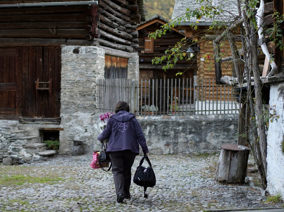 Ein Frau kehrt zurück in ihr Haus in Bondo.