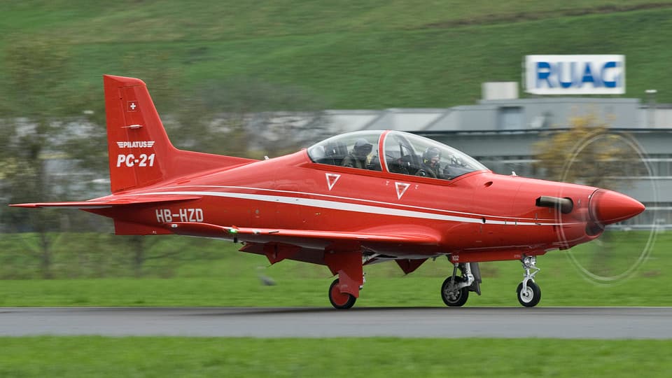 Rotes Flugzeug auf einer Landebahn.