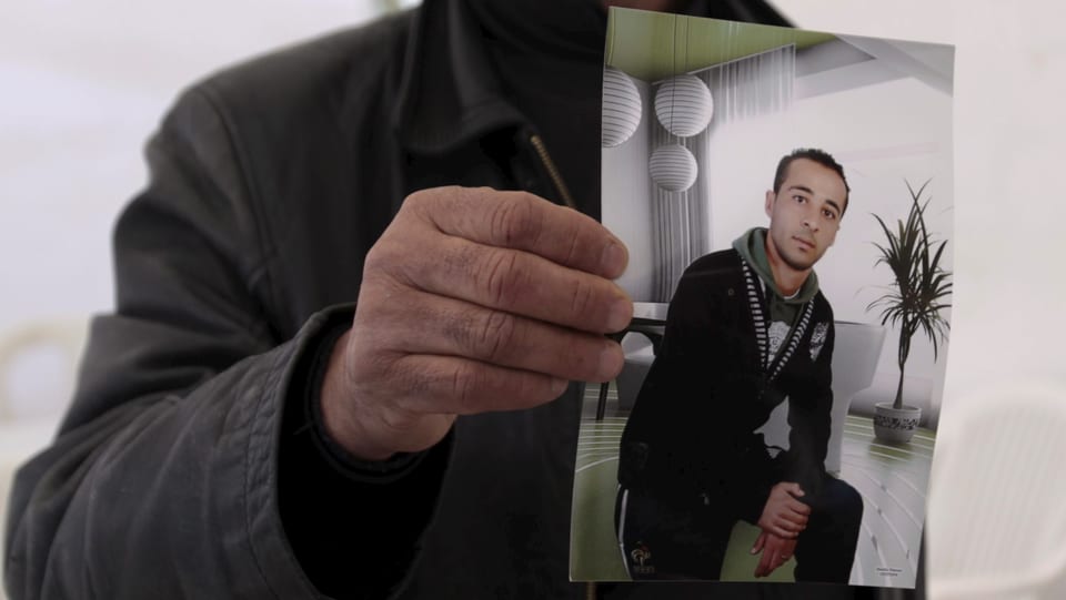 Ein Cousin Yassine al-Abidi hält ein Foto des mutmasslichen Attentäters hoch