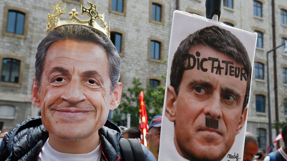 Demonstrant mit Sarkozy-Maske und Valls-Plakat