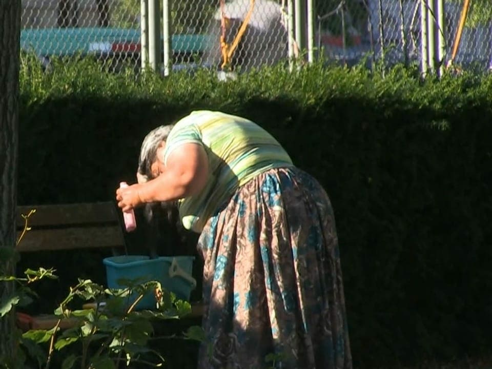Frau wäscht sich Haare im Freien