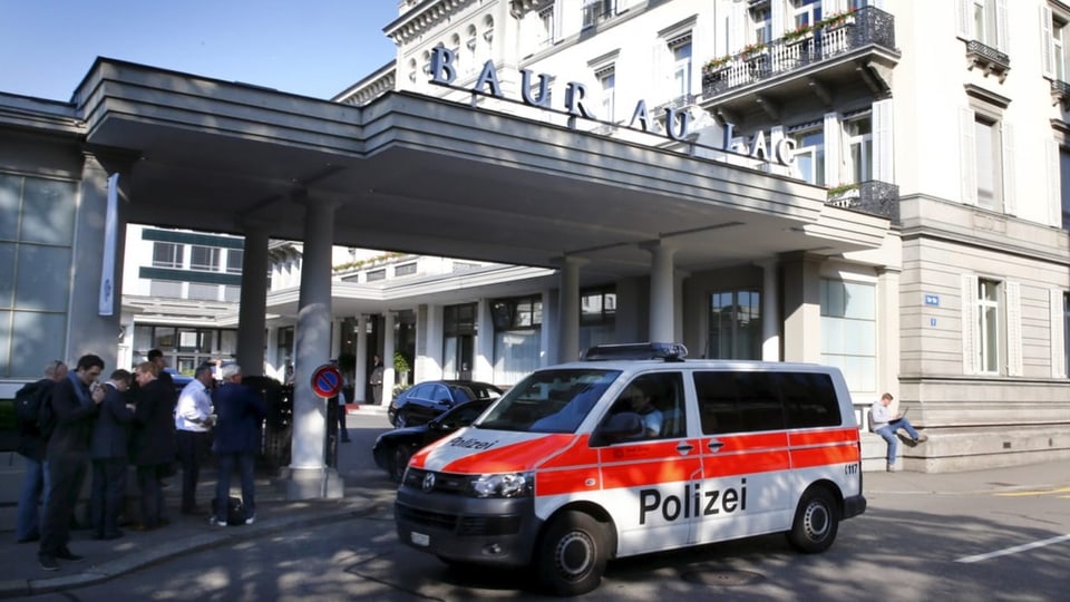 Ein Polizeiauto steht vor dem Hotel Baur au Lac in Zürich. Daneben sind mehre Medienvertreter zu sehen.