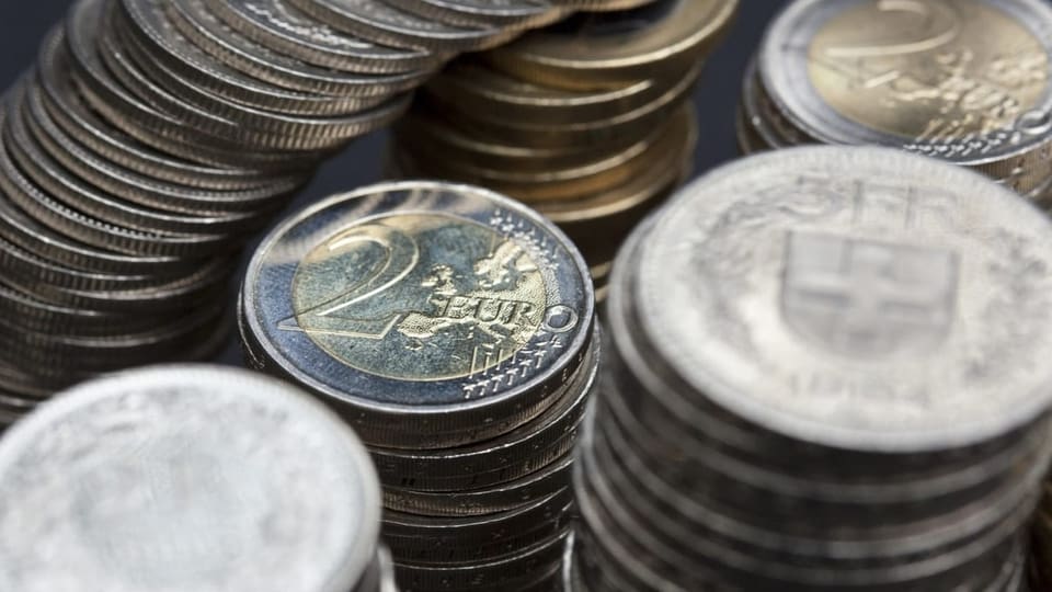 Ein Haufen Euro und Schweizer Franken Münzen sind abgebildet.