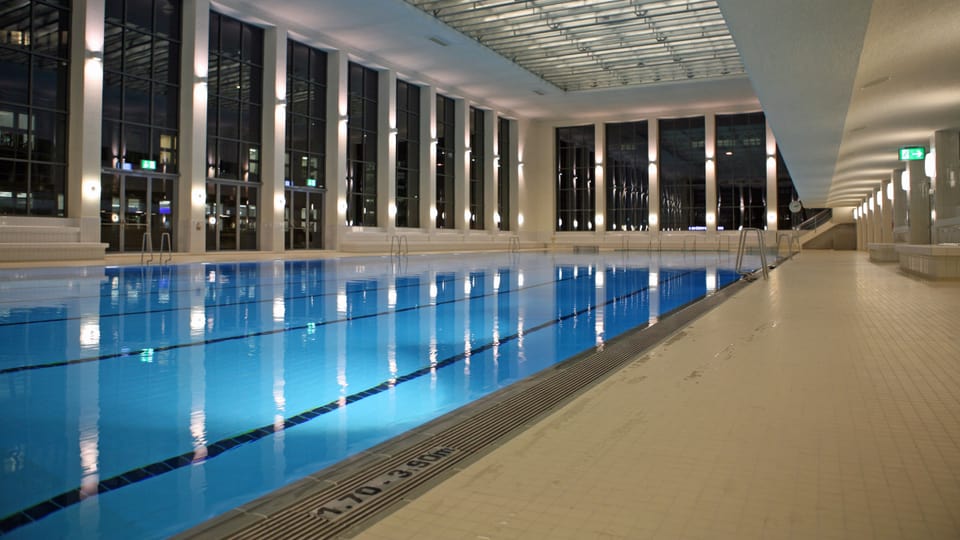 Das 50 Meter lange Schwimmbecken des Hallenbads City mit grosser Fensterfront und dem originalen Glasfaltdach von 1941