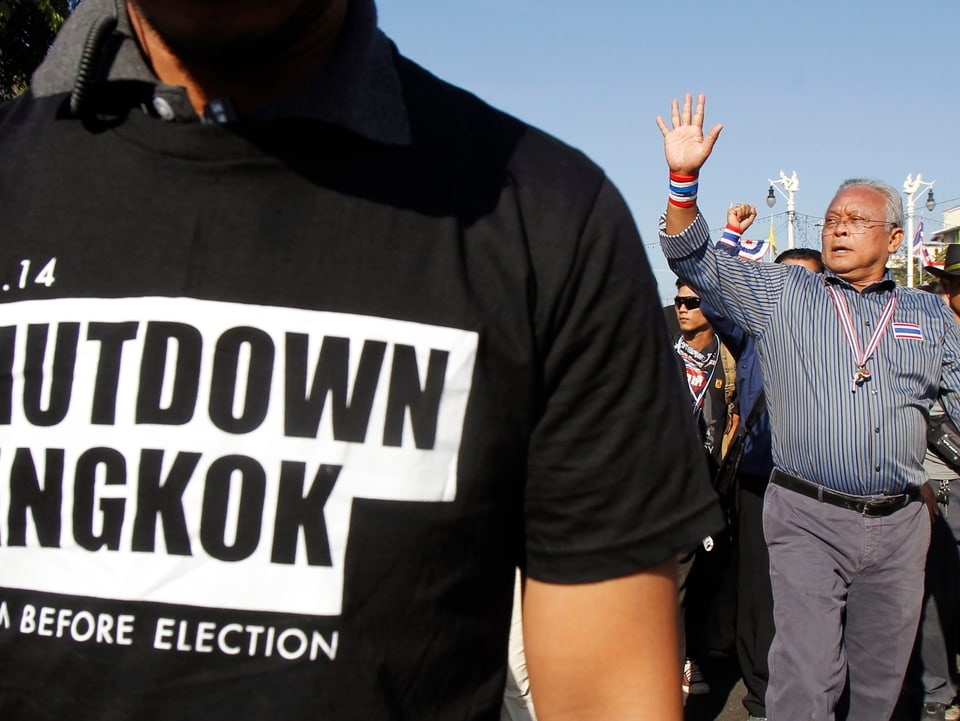 Oppositionsführer Suthep Thaugsuban (rechts) wird von Anhängern in Bangkok begrüsst. Links vor ihm steht ein Mann mit einem bedruckten T-Shirt. Darauf steht: 13.01.2014, Shutdown Bangkok (Bangkok lahm legen). Suthep will mit seinen Zehntausenden Anhängern genau das tun – die Regierung stürzen. (reuters)