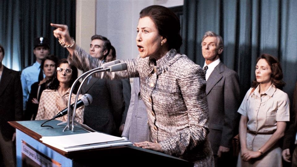 Eine Frau steht an einem Rednerpult und hält eine Rede. Dabei zeigt sie mit dem Finger aufs Publikum.