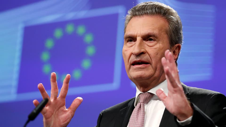 Ein Portrait von Günther Oettinger hinter dem das Logo der EU zu sehen ist.