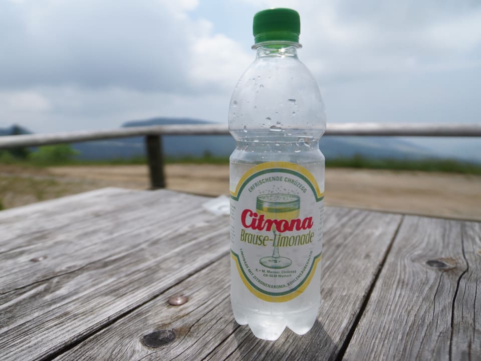 Eine kleine Pet-Flasche mit der Aufschrift «Citrona – Brause-Limonade» auf einem Holztisch.
