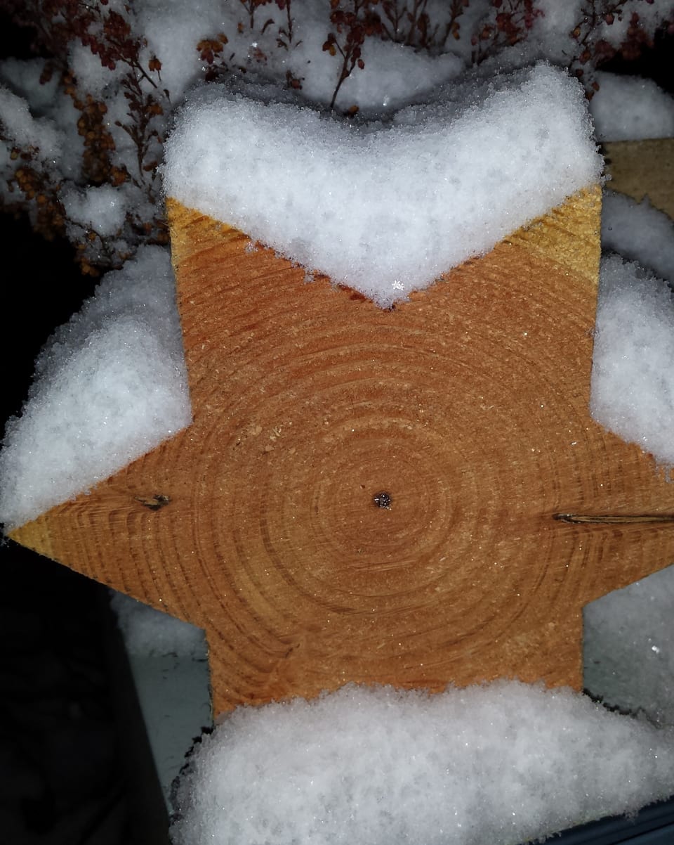 Ein Stern aus Holz im Schnee