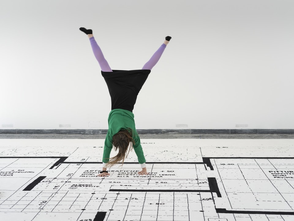 Eine Frau schlägt ein Rad auf einem 18x9 Meter grossen Teppich im Schweizer Pavillon der Architekturbiennale.