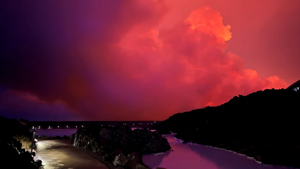 rot-pinker Himmel über einem Hügel, davor spiegelt sich pink im Fluss.