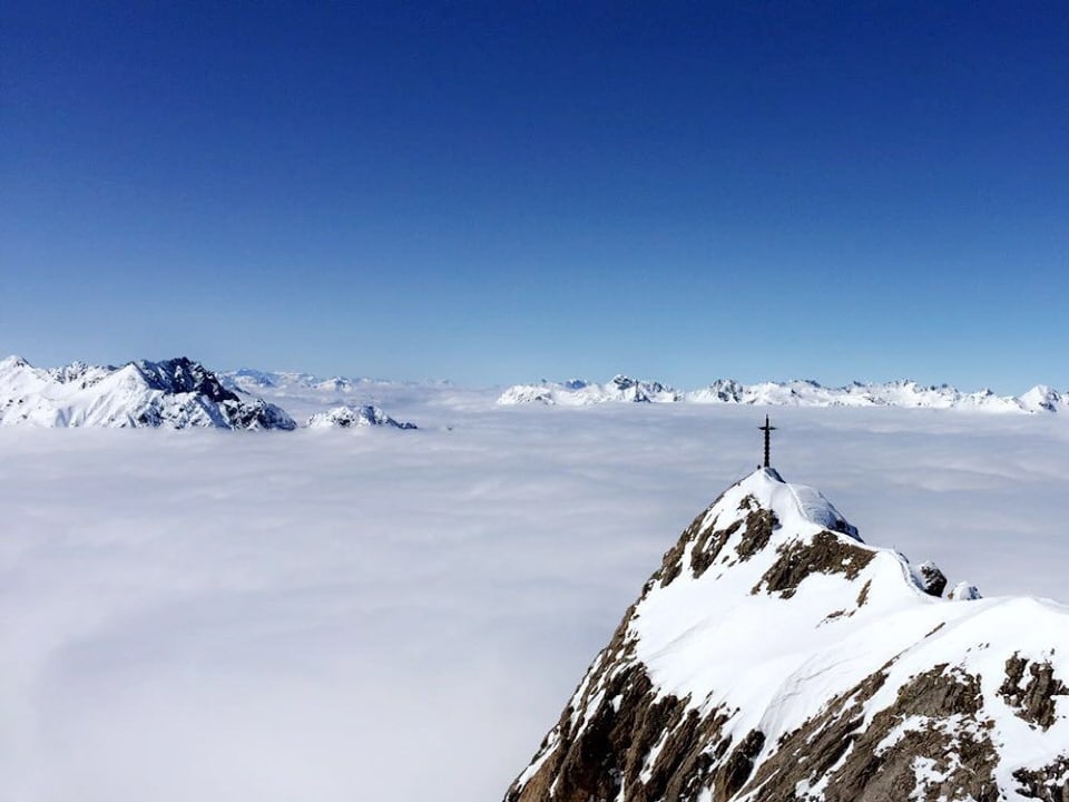 Tiefblauer Himmel, Nebelmeer und einige verschneite Bergspitzen
