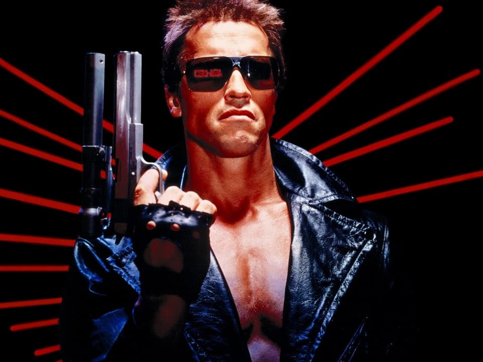 Arnold Schwarzenegger hält als der Terminator eine Pistole in der Hand.