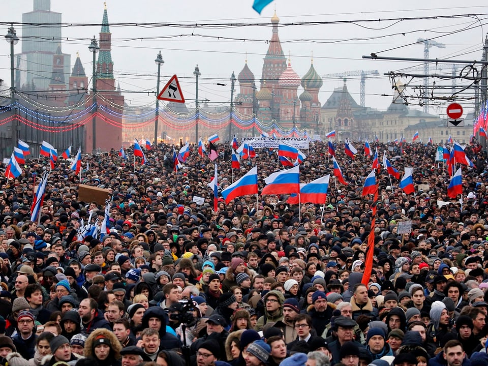 Tausende Demonstrationsteilnehmer, viele schwenken russische Fahnen, im Hintergrund der Kreml