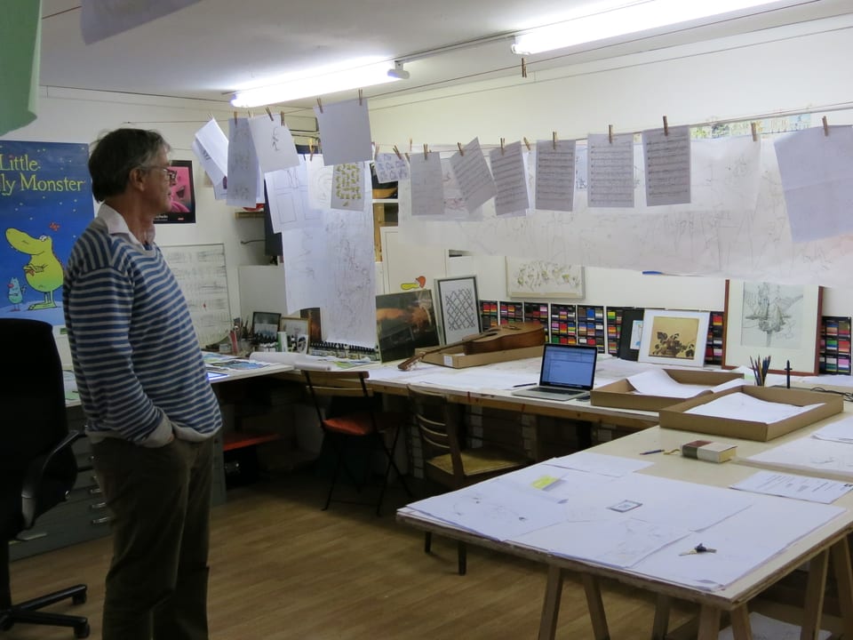 Ted Sieger steht im Atelier, an der Wäscheleinen hängen Skizzen.