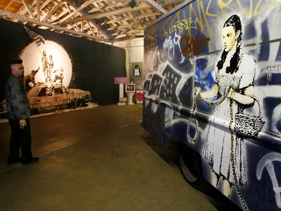 Ein Truck, mit Graffitis und einem Bild der junge Schauspielerin Judy Garland bemalt, steht in einer Ausstellungshalle.
